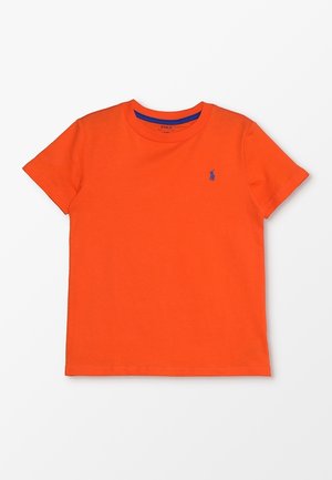 Camiseta de algodón naranja con cuello redondo y mangas cortas. Destaca un acento del logo azul en el pecho. Textura suave, corte regular.