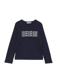 Musta pitkähihainen paita, joka on valmistettu puuvillasta ja jossa on valkoista "CALVIN KLEIN JEANS" -tekstiä toistuvasti edessä. Yksinkertainen pyöreä kaula-aukko, ilman koristeluja.