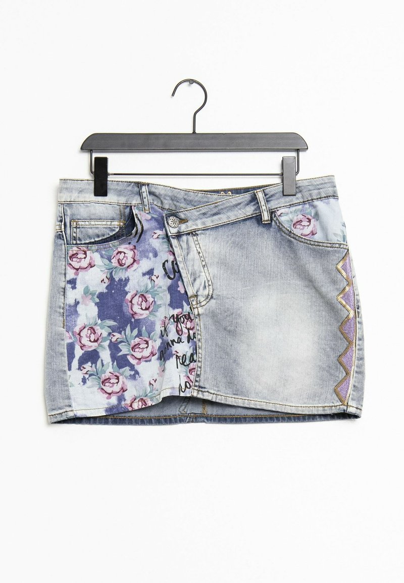 Mini-jupe en denim avec lavage délavé, panneau à imprimé floral sur la gauche, motif zigzag violet sur la droite, suspendue sur un cintre noir sur fond blanc.