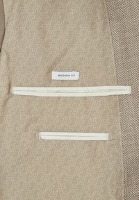 Beige Stoffinnenteil mit geometrischem Muster, ausgestattet mit einem weißen Etikett mit der Aufschrift "MODERN FIT" und zwei mit Cremebraun eingefassten Reißverschlusstaschen.