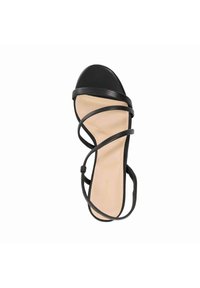 Zwarte strappy sandaal met een glad oppervlak en een ronde neus. Beschikt over meerdere dunne banden die over de voet kruisen, geplaatst op een nude binnenzool.