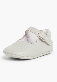 Zapato Mary Jane de cuero gris claro con correa ajustable, borde festoneado, punta redonda y detalles de costura en la suela.