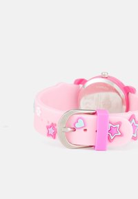 Reloj de silicona rosa con acentos de estrellas y flores multicolores, hebilla de acero inoxidable plateado, cara redonda y acabado mate suave.