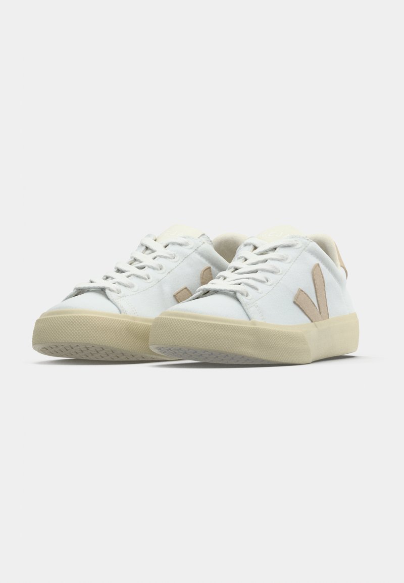 Sneakers bianche con accenti beige, dotate di suola in gomma testurizzata, lacci piatti e design casual a taglio basso.