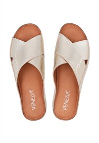 Beige Sandalen mit gekreuzten Riemen und glänzender, strukturierter Oberfläche. Braune Innensohlen mit weißen Nähten. Offene Zehenpartie, flache Sohlen, lässiger Stil.