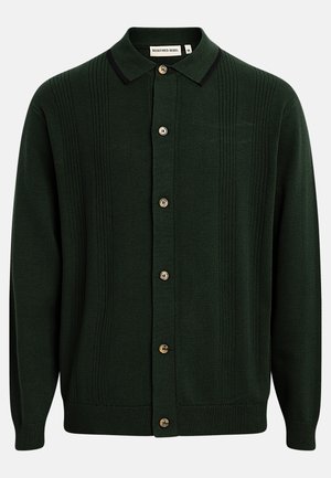 Tamnozeleni pleteni kardigan s crnim obrubom na ovratniku, rebrastim okomitim prugama i šest bež dugmadi sprijeda, srednje veličine.
