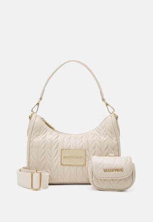 Sac à main crème matelassé avec ferrures dorées, doté d'une bandoulière amovible et d'une petite pochette assortie, toutes deux ornées de détails en relief du logo.