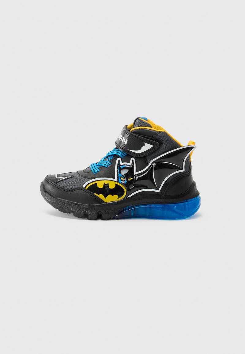 Adidași negri tip gheată cu șireturi albastre, accente galbene și logo-ul lui Batman. Prezintă o talpă translucida albastră și materiale texturate.