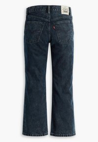 Jean en denim bleu foncé avec une coupe droite, design à cinq poches et une étiquette blanche sur la ceinture affichant les détails de la marque.