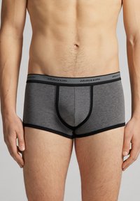Grå bomullsboxer med svart midjeband och detaljer. Har en stödjande formad ficka. Slät textur, åtsittande design.