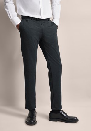 Dark gray trousers made of a textured fabric, featuring a tailored fit and side pockets, paired with black dress shoes.