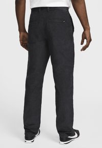 Mörka kordbyxor med lös passform, f�örsedda med bakfickor och en subtil logotypakcent. Slät textur, strömlinjeformat utseende och lättviktig design.