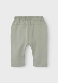 Shorts jogger in cotone verde chiaro con vita elastica, caratterizzati da una superficie liscia e orli cuciti. Senza tasche né decorazioni.