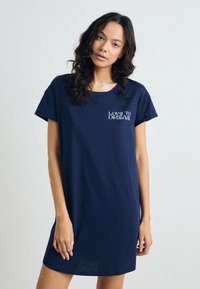 Mörkblå bomulls-t-shirtklänning med korta ärmar, rundad halsringning och texten "LOVE TO DREAM" i vitt på vänster bröst. Slät textur.