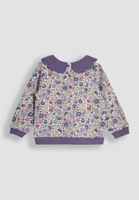 Langærmet trøje i hvid med et farverigt blomsterprint. Har en lilla broderet krave og lilla ribstrikkede manchetter og kant.
