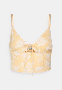 Top crop floral amarelo com alças spaghetti ajustáveis. Apresenta um detalhe de laço na frente e textura franzida abaixo do busto. Tecido suave.