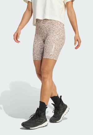 Szorty w panterkę o wysokim stanie, wykonane z miękkiego, rozciągliwego materiału. Charakteryzują się gładkim wykończeniem i detalem z logo na lewej udzie. Czarne buty sportowe.