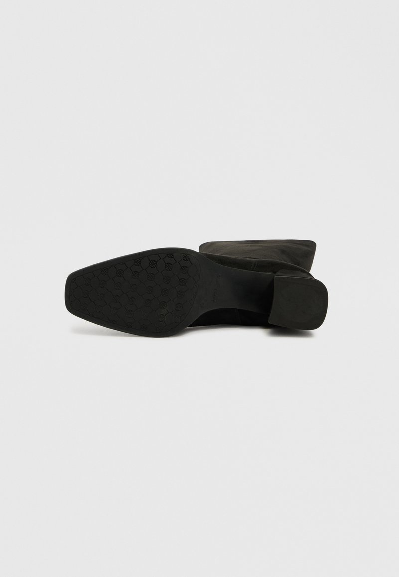 Botín de ante negro con puntera redondeada y tacón bajo en bloque, con suela de goma texturizada que presenta un patrón de panal.