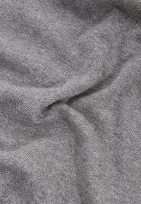 Tessuto grigio con una superficie morbida e texture, caratterizzato da un sottile motivo melange. Presenta pieghe morbide e drappeggi.