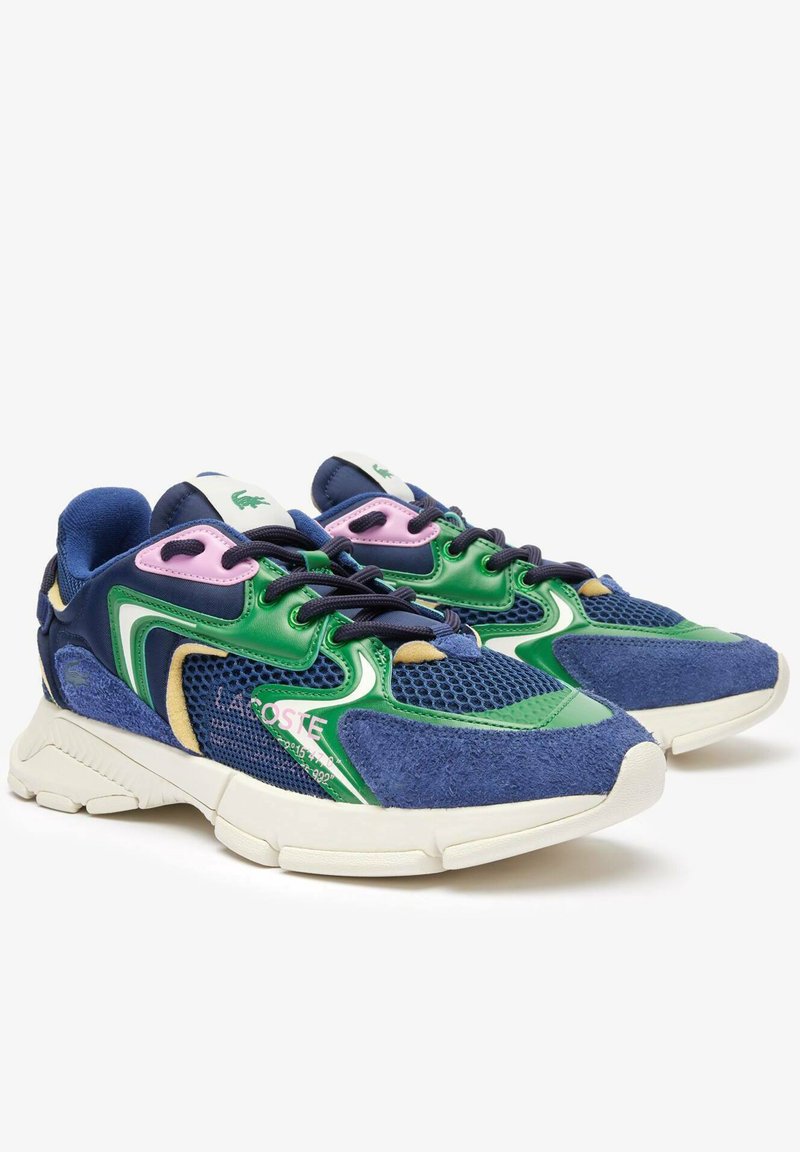 Zapatillas deportivas coloridas con malla azul marino, acentos en verde y rosa, secciones de ante y una gruesa suela de goma blanca con un diseño texturizado.
