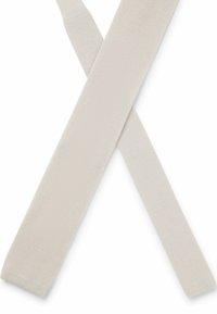 Cravatta intrecciata beige chiaro con una finitura testurizzata, caratterizzata da una forma piatta e punte appuntite. Si incrocia su se stessa nell'immagine.