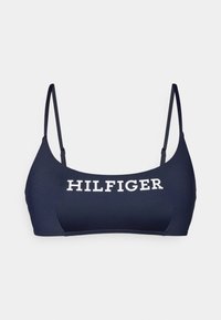 Tamsiai mėlynas bikini viršus, pagamintas iš lygaus audinio, su plonais petnešomis ir ryškiai balta "HILFIGER" logotipu per priekį.