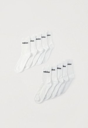 Twee sets van vijf witte Adidas sportsokken met zwarte logotekst, getoond op een effen witte achtergrond.