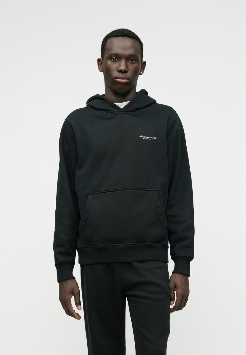 Moleton preto com um bolso frontal, capuz ajustável com cordão, punhos canelados e logótipo bordado no peito. Textura suave, corte descontraído.