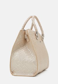 Sac à main beige avec un motif texturé, des poignées tressées, du matériel en argent et une forme effilée, mettant en valeur un design élégant et moderne.