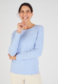 Lichtblauwe langemouwen shirt van zachte, gestructureerde stof met een ronde hals en een licht getailleerd ontwerp. Eenvoudige en veelzijdige stijl.