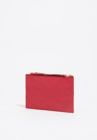 Funda rectangular roja hecha de tela suave con un cierre de cremallera en la parte superior. El diseño es simple, sin patrones ni acentos adicionales.