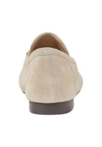 Zapato tipo slip-on de ante beige con parte trasera redondeada, diseño minimalista y tacón bajo marrón. Textura suave con un sutil detalle de costura.