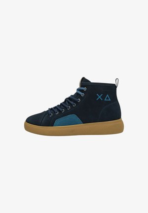 Scarpa da ginnastica alta di colore blu navy con suola in gomma color caramello, toppa blu vicino alla suola, lacci blu e simboli geometrici a X e triangolo sul lato.