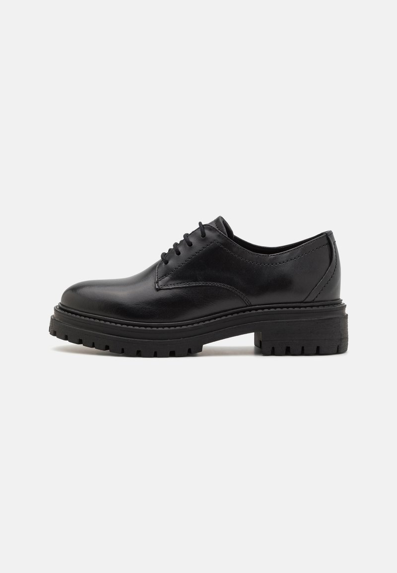 Zapato oxford de cuero negro con un acabado suave, diseño de cordones y suela de goma gruesa con un patrón de textura.