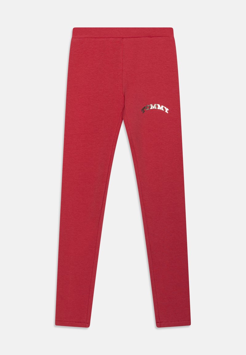 Raudoni leggingai, pagaminti iš minkštos medžiagos, su metaliniu "TOMMY" logotipu kairėje pusėje, prigludę prie kūno ir su siūlėmis.