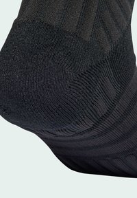 Čierna ponožka s textúrovaným rebrovaným dizajnom a rôznymi vzormi, vyzdvihujúca jemný pletený materiál a bezšvovú konštrukciu na prstoch.