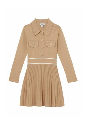 Beige jurk met lange mouwen, kraag, twee voorzakken en knoopsluiting. Plissérok met contrasterende witte stiksels.