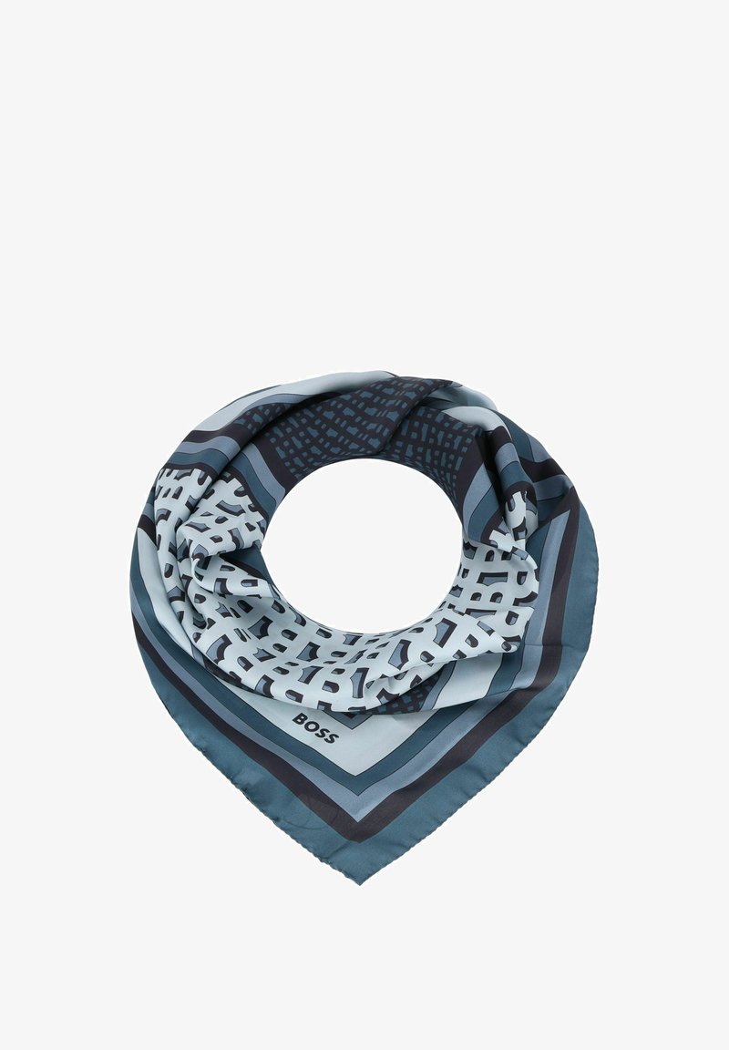 Zijden sjaal in blauwtinten, met geometrische patronen en horizontale strepen. Vierkante vorm met een logo in een hoek.