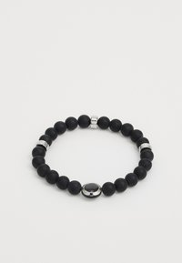 Bracelet en perles noires avec une texture mate lisse, mettant en avant des accents en argent et un détail ovale central. Design uniforme avec des tailles de perles variées.