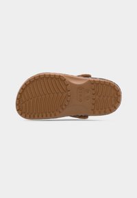 Σόλα καφέ Crocs clog που δείχνει το μοτίβο πέλματος, μέγεθος 11 και τη σήμανση Crocs σε λευκό φόντο.