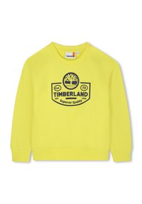 Sweatshirt jaune en tissu texturé, avec des poignets et un ourlet côtelés. Présente un logo bleu marine bien visible portant l'inscription "TIMBERLAND" et l'année de création "73."
