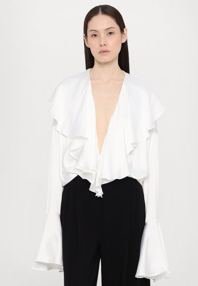 Witte blouse met gerimpelde halslijn en mouwen, een zachte stof, diepe V-hals en een relaxte pasvorm, gecombineerd met zwarte broek.