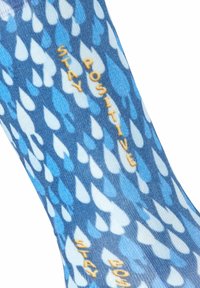 Blaue gemusterte Socken mit Regentropfen-Designs in verschiedenen Blautönen und dem gelben Schriftzug "STAY POSITIVE".