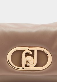 Brun læderhåndtaske med en glat tekstur, der har en guldtonet metal-lukning med logo og en rund form.