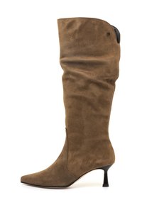 Botte en suède marron jusqu'au genou avec un bout pointu et un petit talon aiguille noir, présentant un léger plissage sur la tige et un petit logo en métal près du haut.