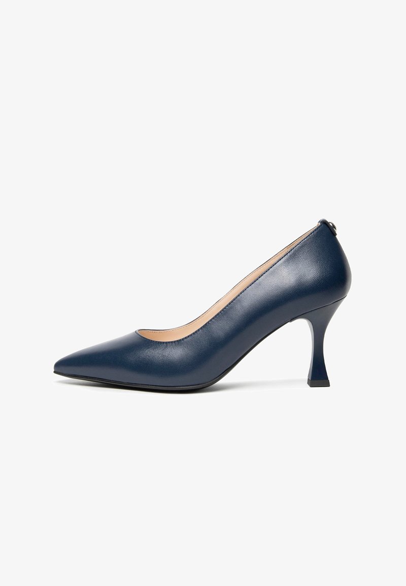 Pompe en cuir bleu marine avec un bout pointu, un design à décolleté bas, un talon effilé et un dos accentué. Texture lisse avec un minimum de détails.