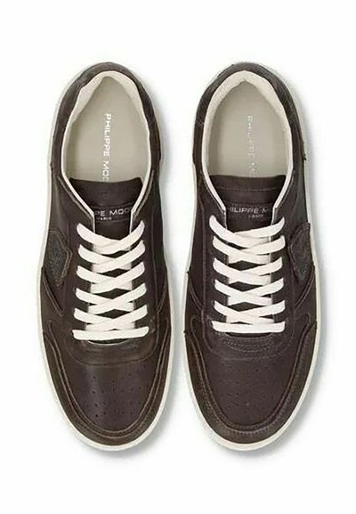 Sneakers in pelle marrone con lacci bianchi, dettagli perforati e cuciture a contrasto. Suola in gomma piatta e logo all'interno.