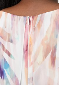 Wielokolorowa, zwiewna sukienka z wodnym kwiatowym wzorem, z dyskretnym zamkiem błyskawicznym z tyłu i miękkim, lekkim materiałem.