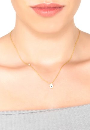 Złoty naszyjnik z łańcuszkiem, ozdobiony wisiorkiem w kształcie ręki z niebieskim elementem dekoracyjnym. Wisiorek i łańcuszek mają gładkie, błyszczące wykończenie.