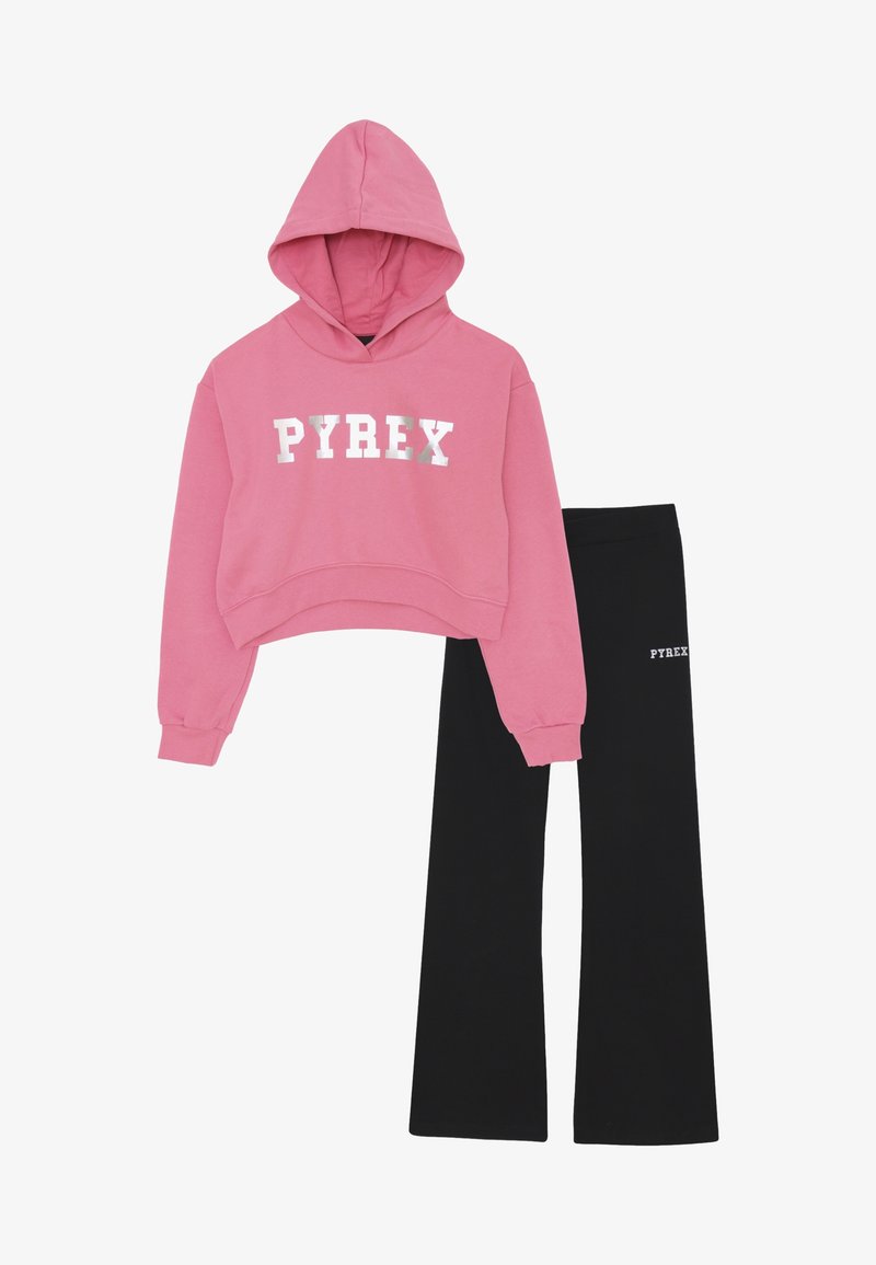 Felpa corta rosa con stampa "PYREX" e pantaloni neri a campana con piccolo logo "PYREX" sulla coscia, disposti su uno sfondo bianco.